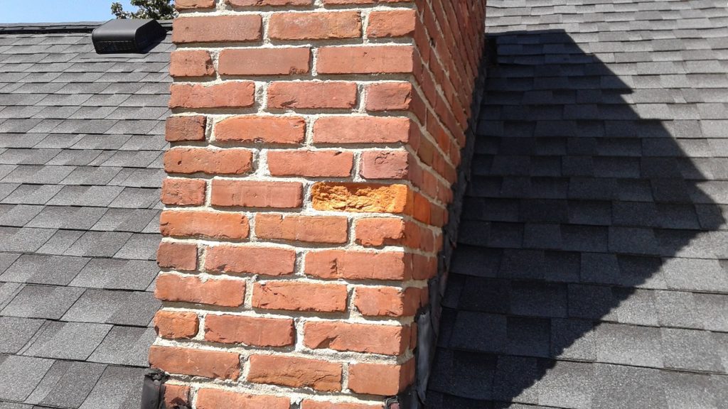 The spalled chimney brick is in need of repair.