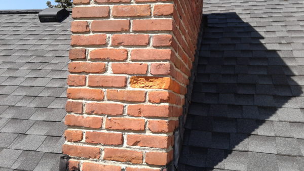The spalled chimney brick is in need of repair.